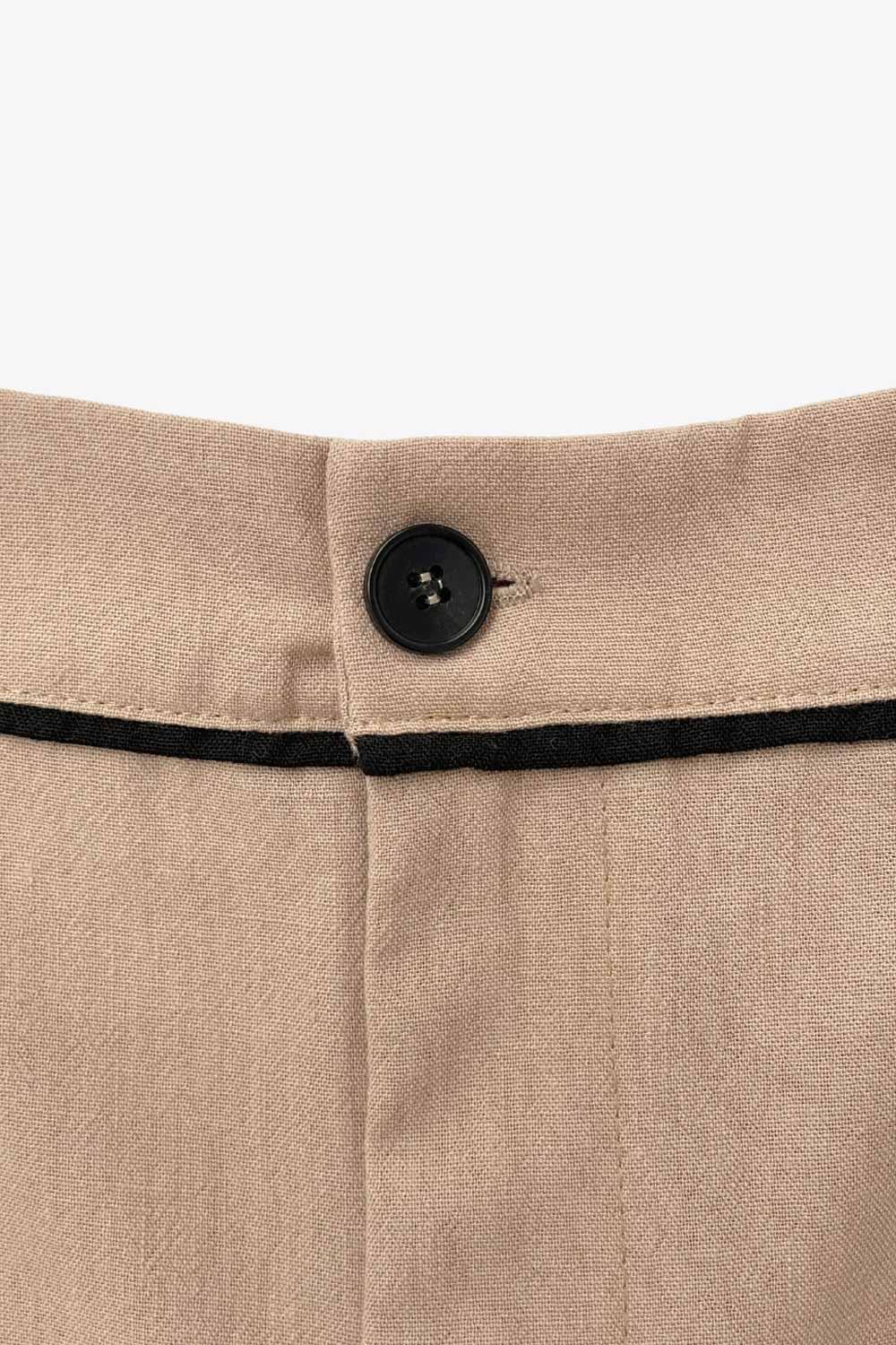 Short de fit recto, cintura alta con pretina y trabillas, bolsillos delanteros, pinzas frontales, cierre frontal con botón y cremallera oculta. Detalle de ribete decorativo en contraste.