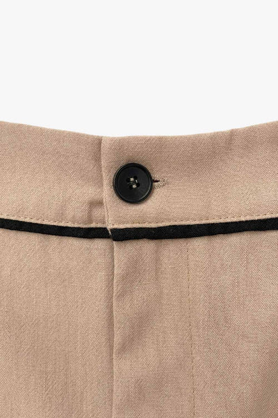 Short de fit recto, cintura alta con pretina y trabillas, bolsillos delanteros, pinzas frontales, cierre frontal con botón y cremallera oculta. Detalle de ribete decorativo en contraste.