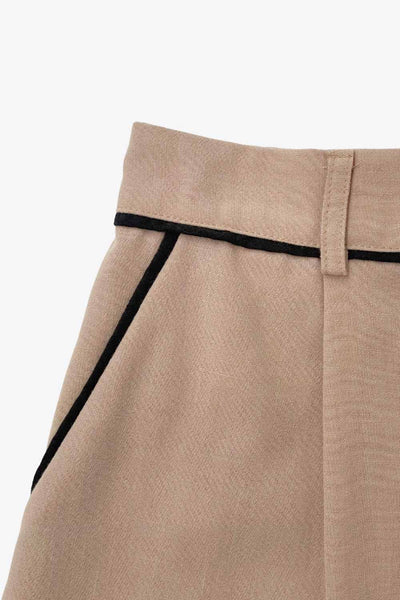 Short de fit recto, cintura alta con pretina y trabillas, bolsillos delanteros, pinzas frontales, cierre frontal con botón y cremallera oculta. Detalle de ribete decorativo en contraste.