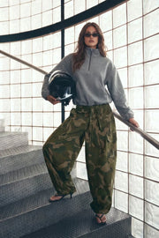 Sudadera de fit ligeramente oversized, manga larga con hombro caído, cuello sport, bolsillos delanteros y rib elástico en puños. Detalle de jaretas elásticas ajustables laterales en bajo. Cierre frontal con cremallera. Detalle de costura decorativo posterior.