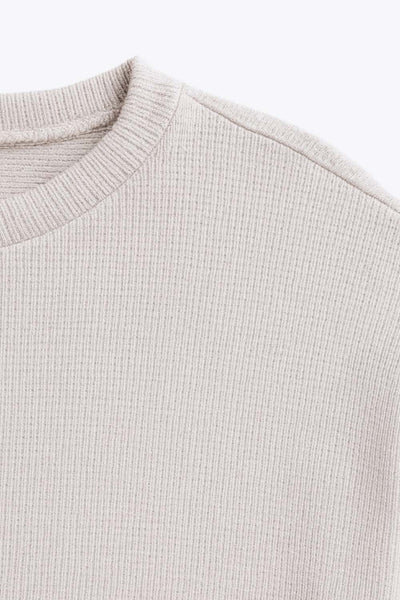 Jersey básico de punto, fit recto, cuello redondo, manga larga de hombro caído y rib en puños.