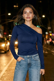 Top de fit ajustado, plisados en hombro, manga larga y cuello diagonal asimétrico con hombro descubierto.