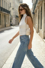 Top de fit ajustado, sin mangas, escote en espalda, cuello halter con plisados y nudo amarrable.