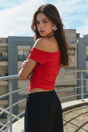Top ajustado sin mangas, de cuello diagonal con hombro descubierto, plisados en hombros y bajo frontal asimétrico.
