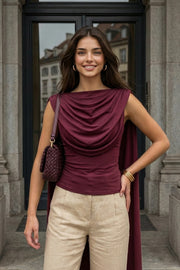 Top de fit ajustado, sin mangas, cuello redondo y detalle decorativo frontal con plisados en hombros.