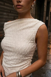 Top ajustado sin mangas, de cuello diagonal con hombro descubierto, plisados en hombros y costados. Detalle de textura en tejido.