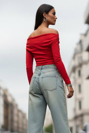 Top de fit ajustado, hombros descubiertos, escote recto y manga larga seguida con plisados laterales. Detalle de plisados en costados.