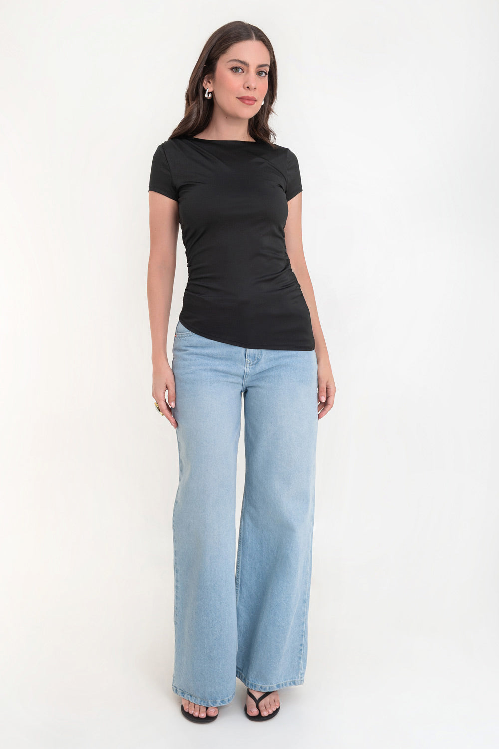 Top de fit ajustado, manga corta, cuello barco, plisados en costados y bajo curveado asimétrico.