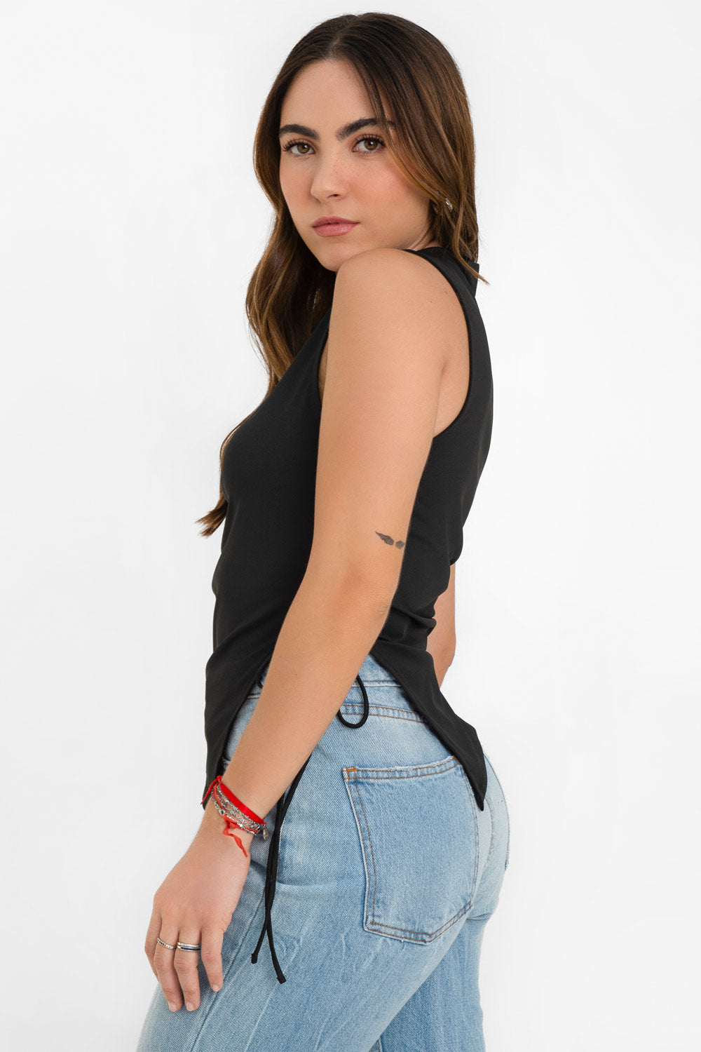 Top asimétrico de fit recto, cuello barco, sin mangas, bajo asimétrico diagonal con abertura lateral y lazo amarrable decorativo.