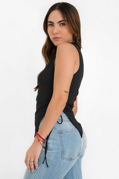 Top asimétrico de fit recto, cuello barco, sin mangas, bajo asimétrico diagonal con abertura lateral y lazo amarrable decorativo.