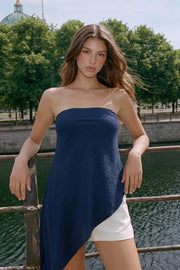 Top strapless de fit fluido, escote recto elástico y bajo diagonal asimétrico con olanes.