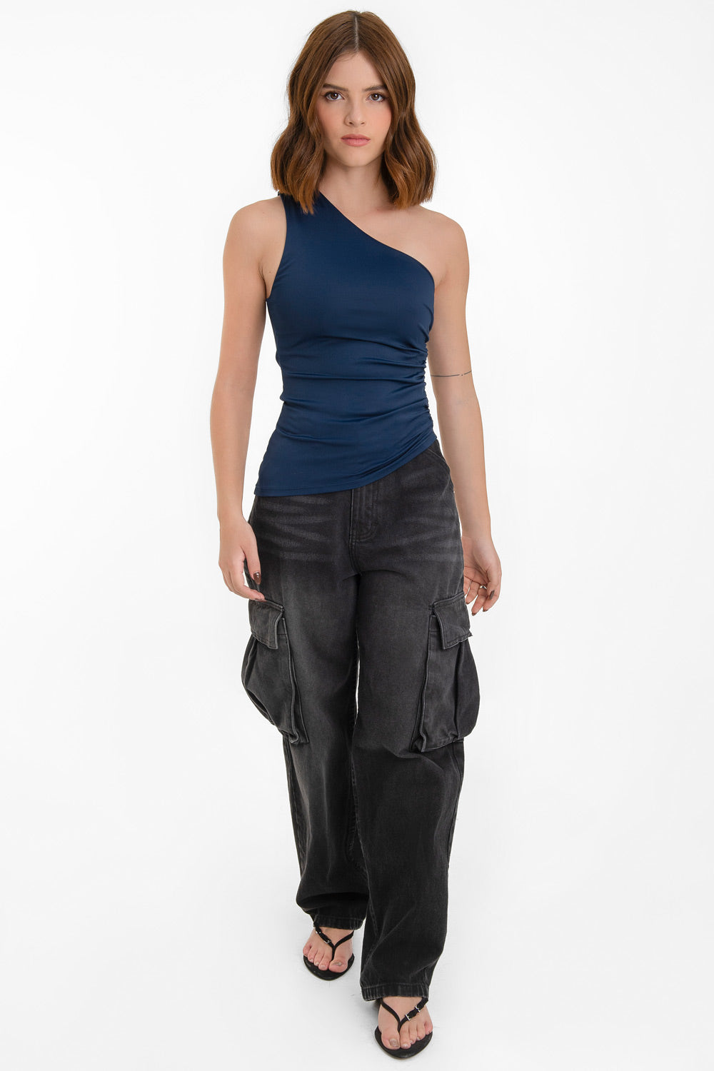 Top asimétrico de fit ajustado, un hombro, escote diagonal, plisados en costado y detalle de bajo asimétrico curveado.