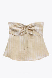 Top corto de estampado rayas, cuello halter con lazo amarrable posterior, escote corazón con jareta ajustable y plisados frontales. Detalle de peplum con olanes y fruncido en espalda.