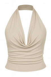 Top corto ajustado de cuello halter con escote fluido, sin mangas, escote en espalda, cierre posterior con botón y ojal.