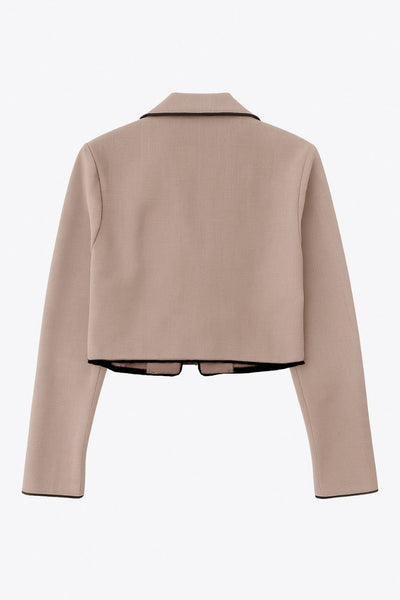 Top blazer corto de fit fluido, manga larga, escote v con solapa y cierre frontal con lazos amarrables. Detalle de ribete decorativo en contraste.