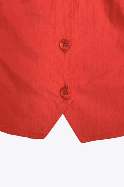 Top corto de fit recto, sin mangas, cuello redondo, bajo v frontal y cierre con hilera de botones.