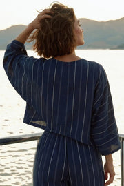 Blusa tipo capa de fit fluido, estampado rayas, manga larga amplia, cuello v y bajo asimétrico.