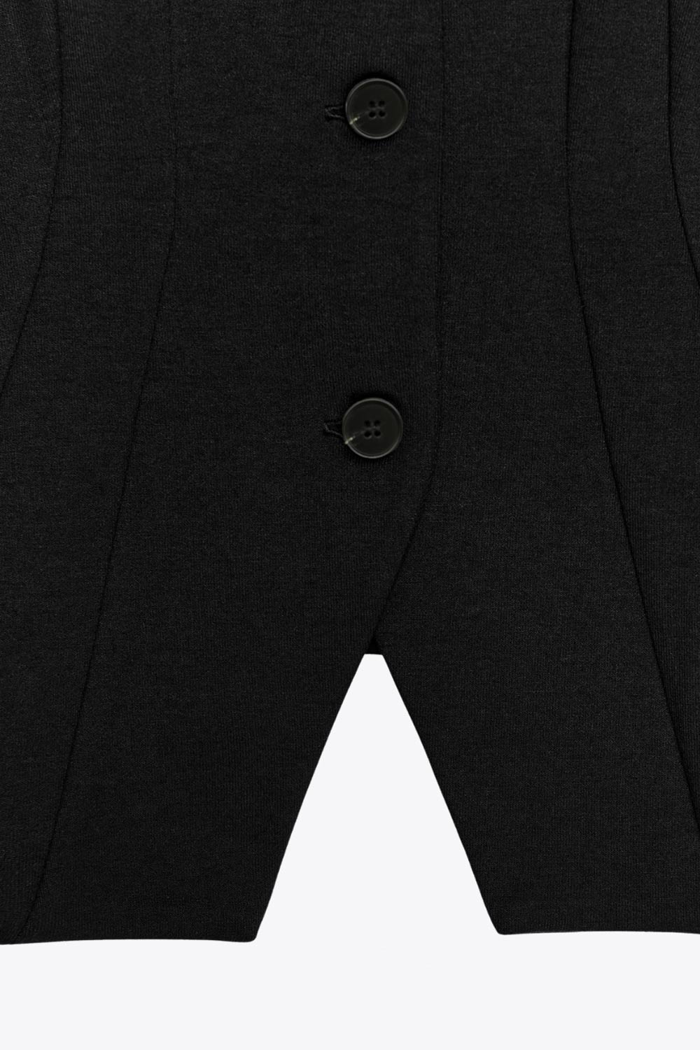 Chaleco de fit ajustado, cuello v, con hombreras y cierre frontal con hilera de botones. Detalle de abertura frontal en bajo.