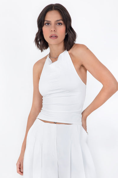 Top corto de cuello halter fluido, sin mangas, fit ajustado y escote en espalda.