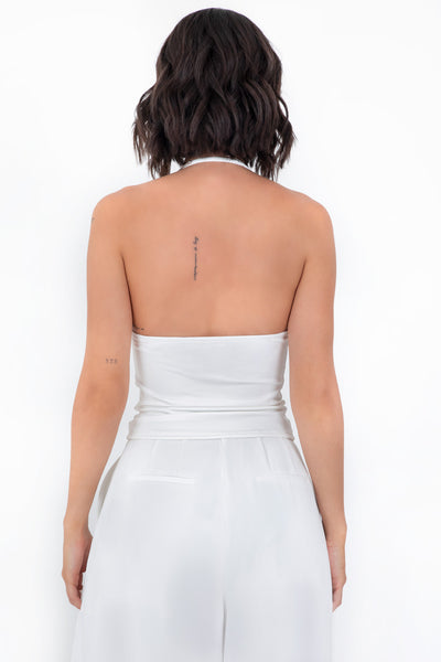 Top corto de cuello halter fluido, sin mangas, fit ajustado y escote en espalda.