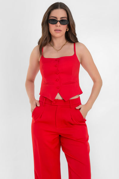 Top corto de fit ajustado, pinzas frontales, escote recto, tirantes delgados, vivos decorativos y cierre frontal con hilera de botones forrados. Detalle bajo v frontal.