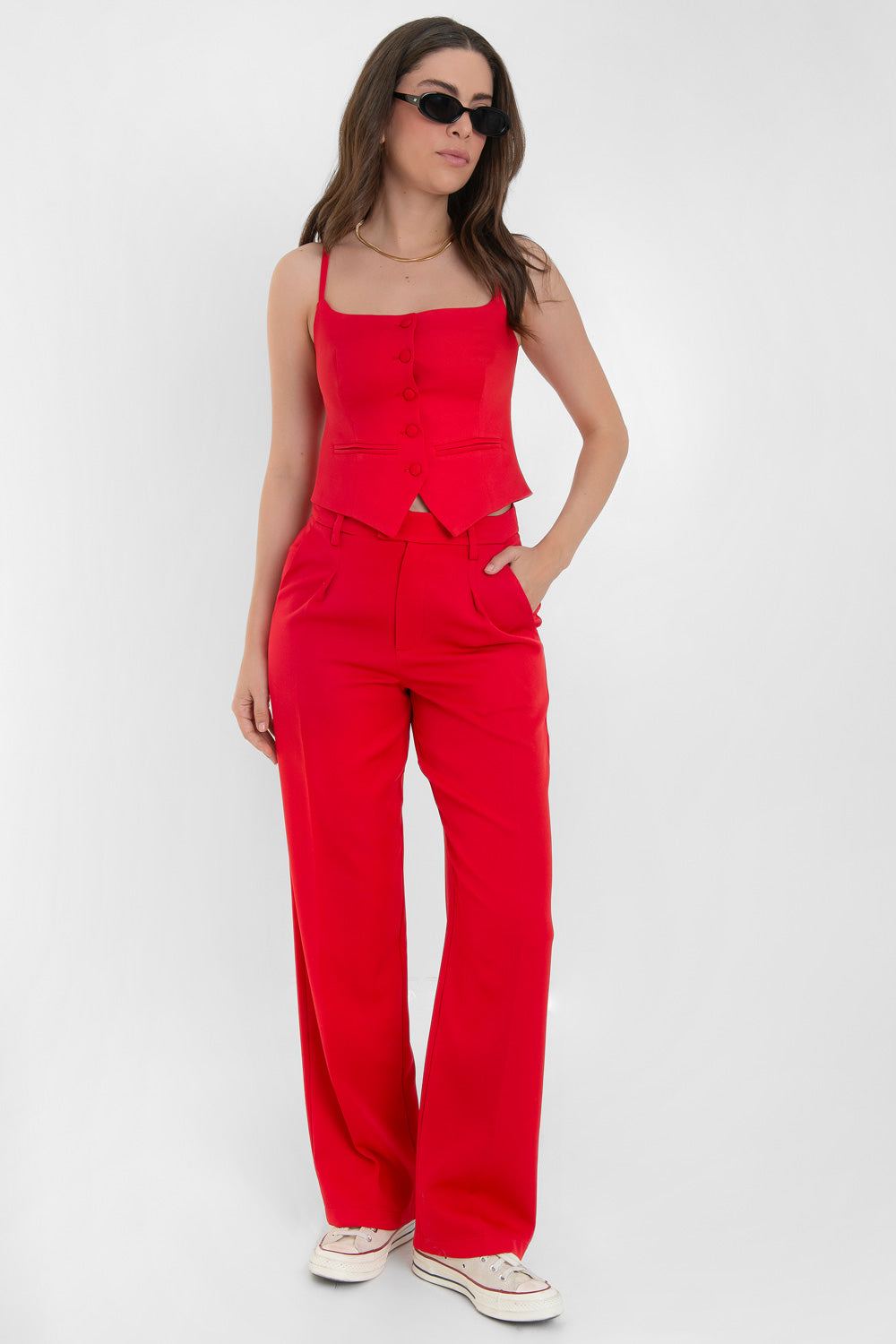 Top corto de fit ajustado, pinzas frontales, escote recto, tirantes delgados, vivos decorativos y cierre frontal con hilera de botones forrados. Detalle bajo v frontal.