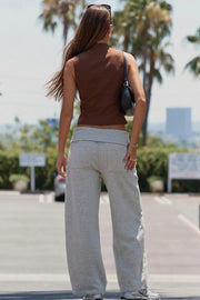 Top corto de fit ajustado, sin mangas, cuello mao, cierre frontal con botones y bajo frontal curveado.
