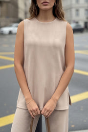 Top canalé de punto, fit fluido, cuello redondo, sin mangas y detalle de aberturas laterales en bajo.
