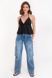 Top corto halter de escote v con lazo amarrable frontal, rib elástico en espalda, tirantes halter con lazo amarrable posterior y abertura frontal en bajo. Detalle de peplum olanes y textura en tejido.