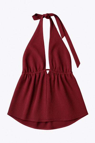 Top canalé de cuello halter con nudo amarrable posterior, escote v con plisados frontales, rib elástico en cintura y peplum olanes. Detalle de escote en espalda con lazo amarrable posterior.