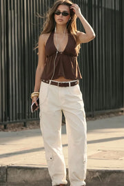 Top corto de cuello halter con lazo amarrable posterior, escote v con plisados, rib elástico en espalda y lazo amarrable en espalda. Detalle de peplum olanes en bajo.