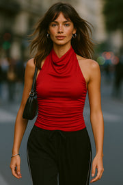 Top halter de fit ajustado, cuello alto fluido, sin mangas, plisados en costados y cierre posterior con botón y ojal.