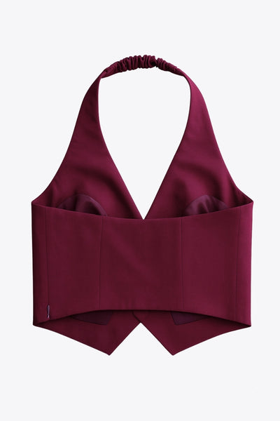 Chaleco corto cuello halter de fit ajustado, escote v, cierre lateral con cremallera oculta, vivos decorativos frontales y bajo v frontal. Escote en espalda y rib elástico posterior.