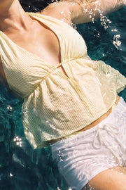 Top corto de cuello halter con lazo amarrable posterior, estampado rayas, escote v con plisados, rib elástico en espalda y lazo amarrable en espalda. Detalle de peplum olanes en bajo.