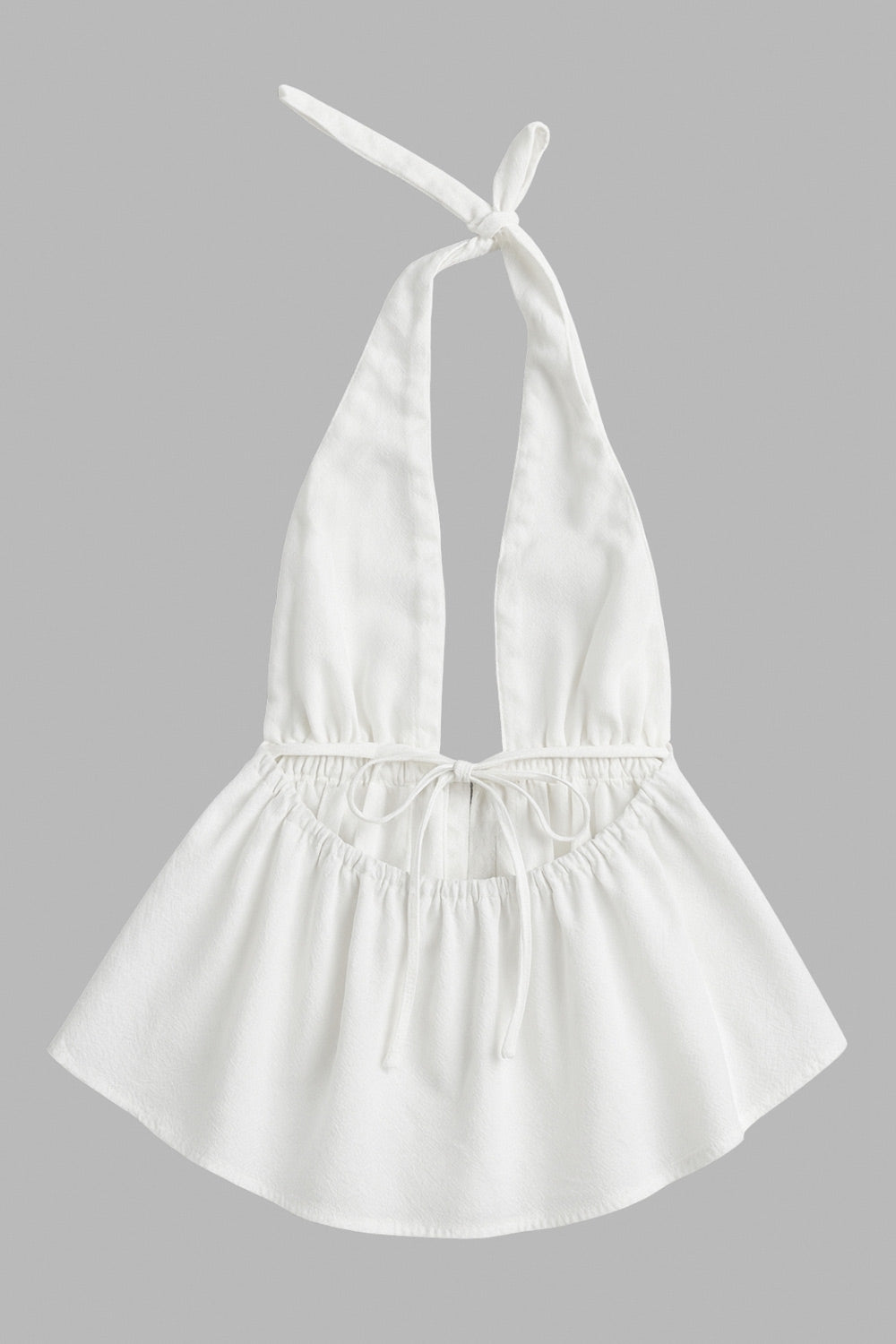 Top de cuello halter con nudo amarrable posterior, escote v con plisados frontales, rib elástico en cintura y peplum olanes. Detalle de escote en espalda con lazo amarrable posterior.