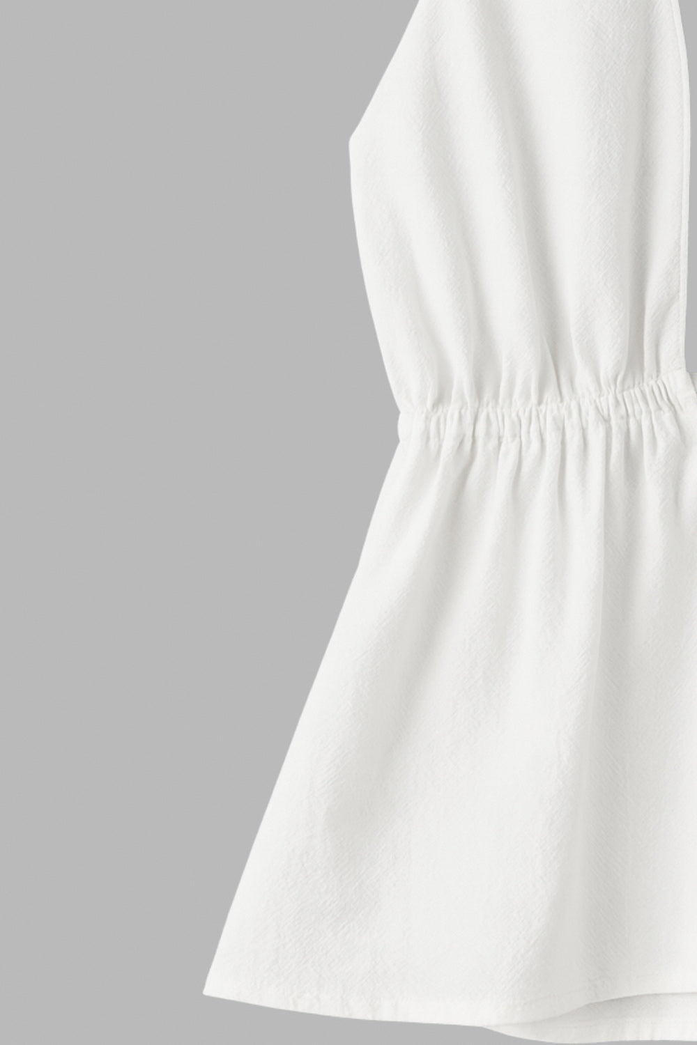 Top de cuello halter con nudo amarrable posterior, escote v con plisados frontales, rib elástico en cintura y peplum olanes. Detalle de escote en espalda con lazo amarrable posterior.