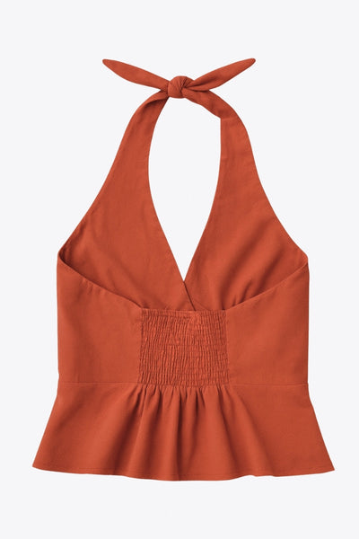 Top corto de cuello halter con nudo amarrable posterior, escote v con cortes y plisados decorativos frontales, fit ajustado, escote en espalda con fruncido posterior, cierre frontal con hilera de botones y abertura en bajo.