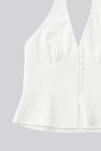 Top corto de cuello halter con nudo amarrable posterior, escote v con cortes y plisados decorativos frontales, fit ajustado, escote en espalda con fruncido posterior, cierre frontal con hilera de botones y abertura en bajo.