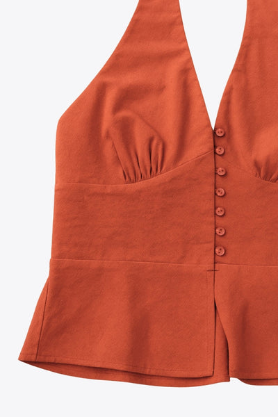 Top corto de cuello halter con nudo amarrable posterior, escote v con cortes y plisados decorativos frontales, fit ajustado, escote en espalda con fruncido posterior, cierre frontal con hilera de botones y abertura en bajo.