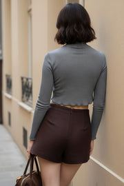 Top de manga larga con hombro caído, cuello mock seguido, fit recto, textura en tejido, detalle de rib en borde de bajo y puños.
