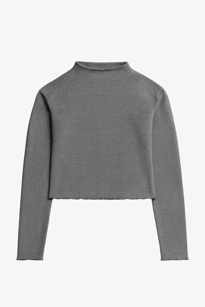 Top de manga larga con hombro caído, cuello mock seguido, fit recto, textura en tejido, detalle de rib en borde de bajo y puños.