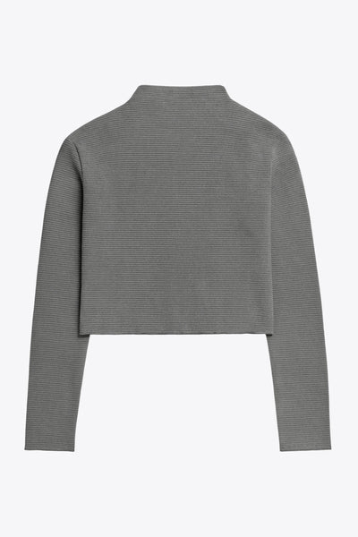 Top de manga larga con hombro caído, cuello mock seguido, fit recto, textura en tejido, detalle de rib en borde de bajo y puños.