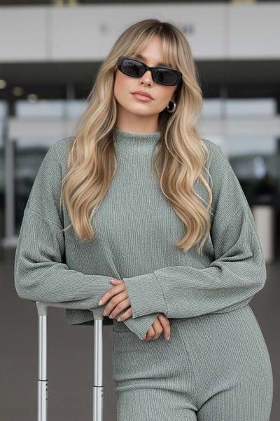 Top de manga larga con hombro caído, cuello mock seguido, fit recto y textura en tejido.