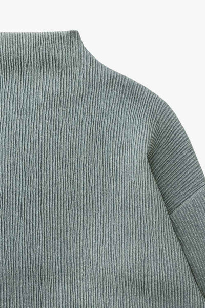 Top de manga larga con hombro caído, cuello mock seguido, fit recto y textura en tejido.