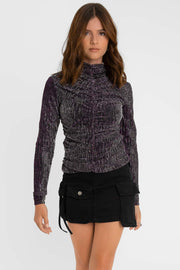 Top de fit ajustado, cuello mock seguido, manga larga, plisado frontal y posterior. Detalle de hilo metálico en tejido.