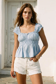 Top corto de escote v redondeado y manga corta con rib elástico y olanes en borde, elástico en cintura y peplum con olanes en bajo.