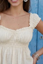 Top corto de escote v redondeado y manga corta con rib elástico y olanes en borde, elástico en cintura y peplum con olanes en bajo.