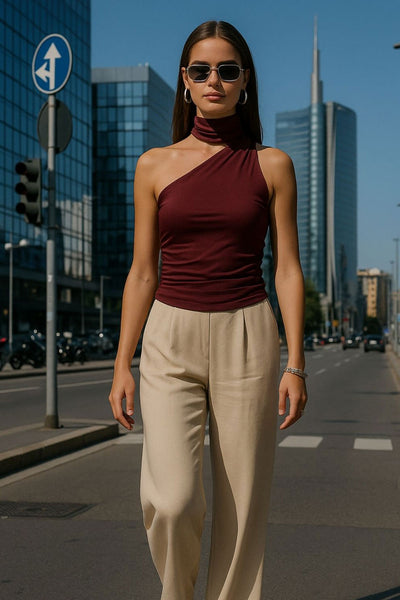 Top satinado asimétrico, de fit ajustado, detalles plisados laterales y en hombro, sin mangas, un hombro, escote diagonal y choker con plisados. Cierre posterior con botón y ojal.