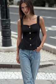 Top de fit ajustado, sin mangas, escote cuadrado, cortes frontales y peplum con olanes en bajo. Cierre frontal con hilera de botones en contraste.