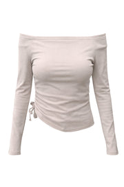 Top de fit ajustado, hombros descubiertos, manga larga, plisados en costado con jareta ajustable y bajo curveado.